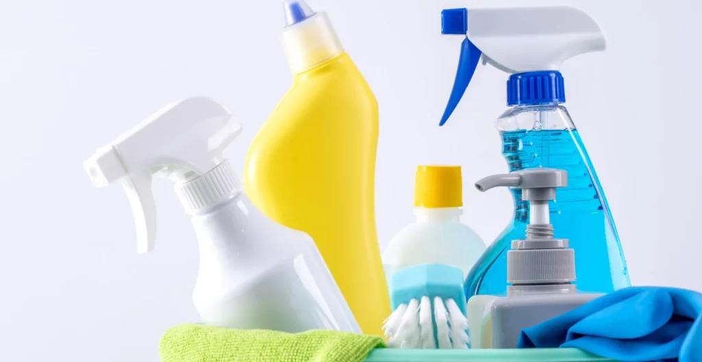 Flacons de produits ménagers alignés sur fond clair
